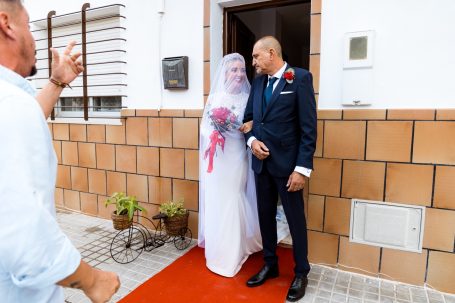Mirada complice entre la novia y el padrino al salir para la iglesia de la Algaba, Sevilla