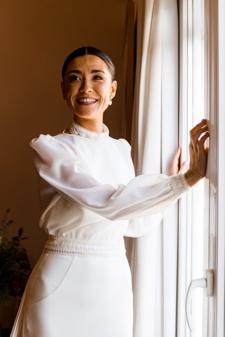 Carla sonriente ante la ventana de su casa en Castilleja de la cuesta
