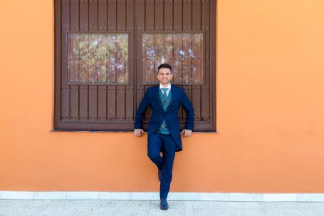 Novio posando sobre la pared en su boda en la Hacienda Albaraka, dos hermanas